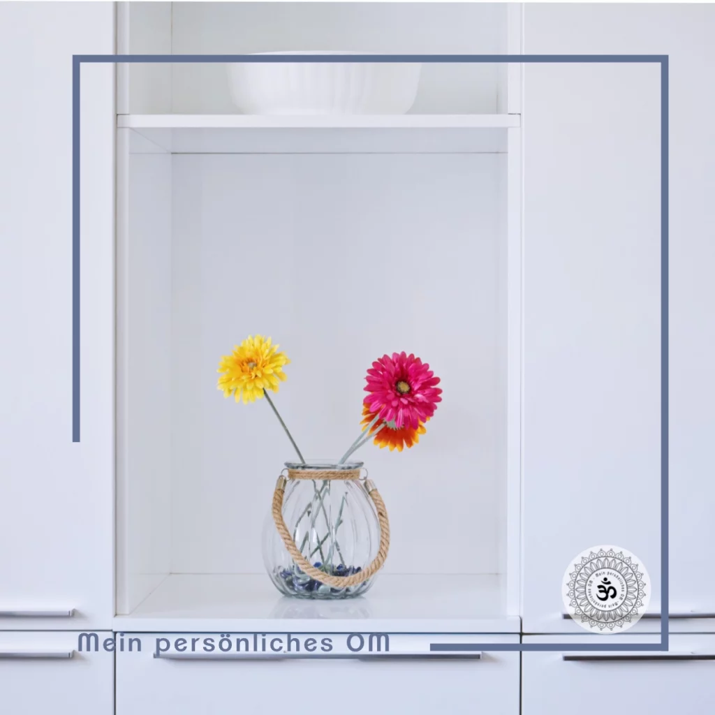 Minimalistische Innenausstattung der weißen Küche mit bunten Blumen in der Vase. Glänzende Schrankoberfläche